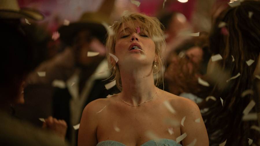 Grace do filme Morra, Amor no centro de um salão de olhos fechados em transe coberta de confetes que caem