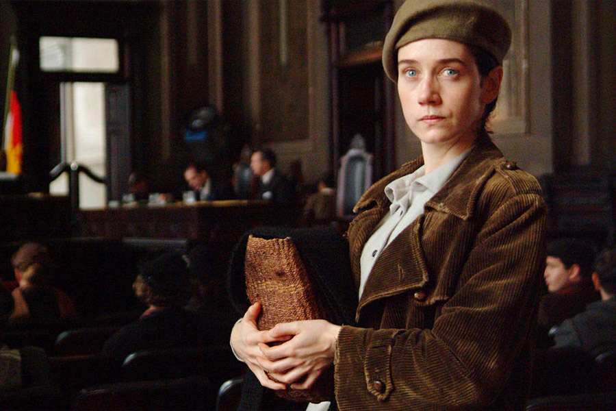 Olga com boine segurando livros em tribunal